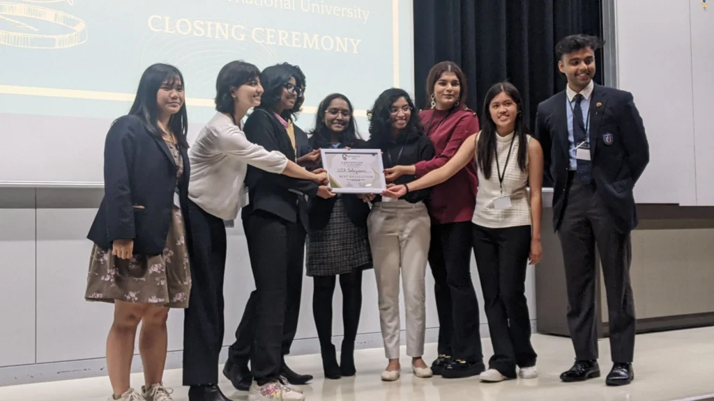 Group of students receiving a certificate on stage during a closing ceremony event.