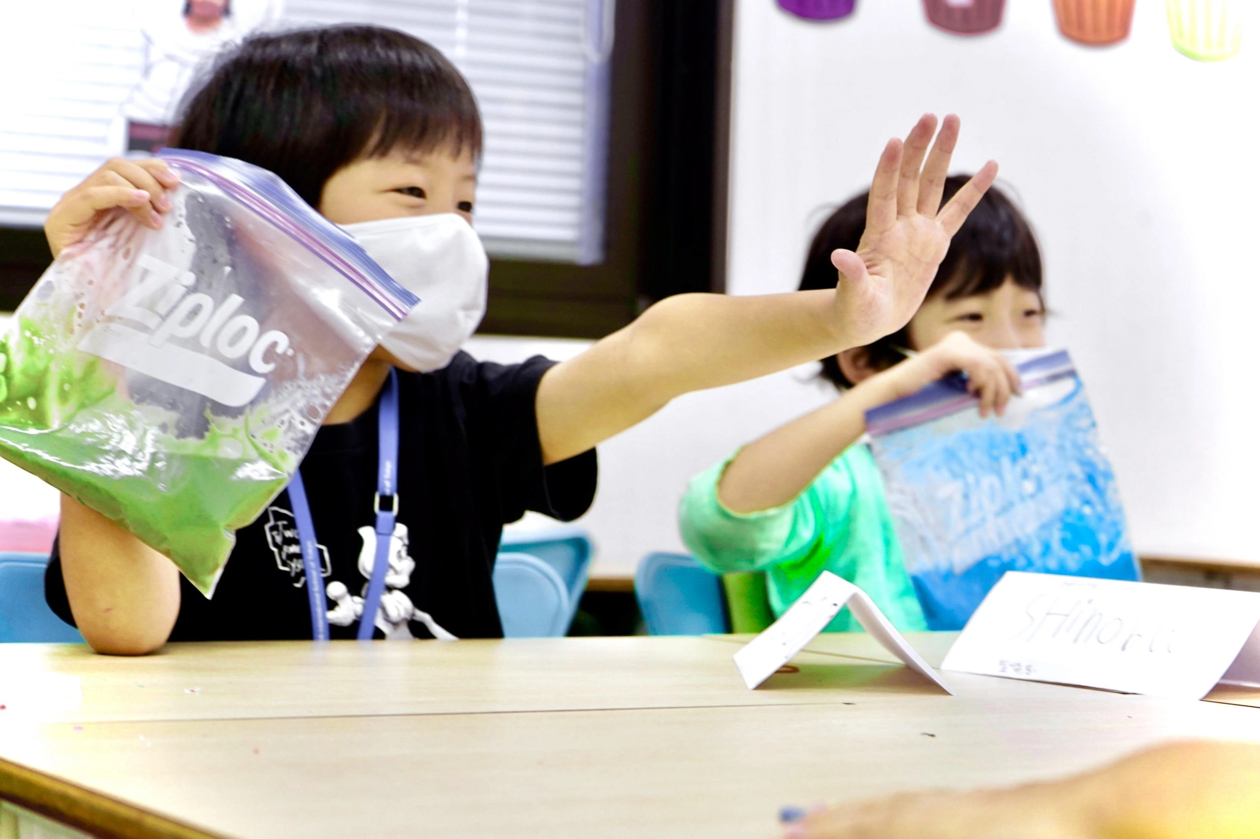 Children engaging in a fun classroom activity with colored bags, smiling and learning together.