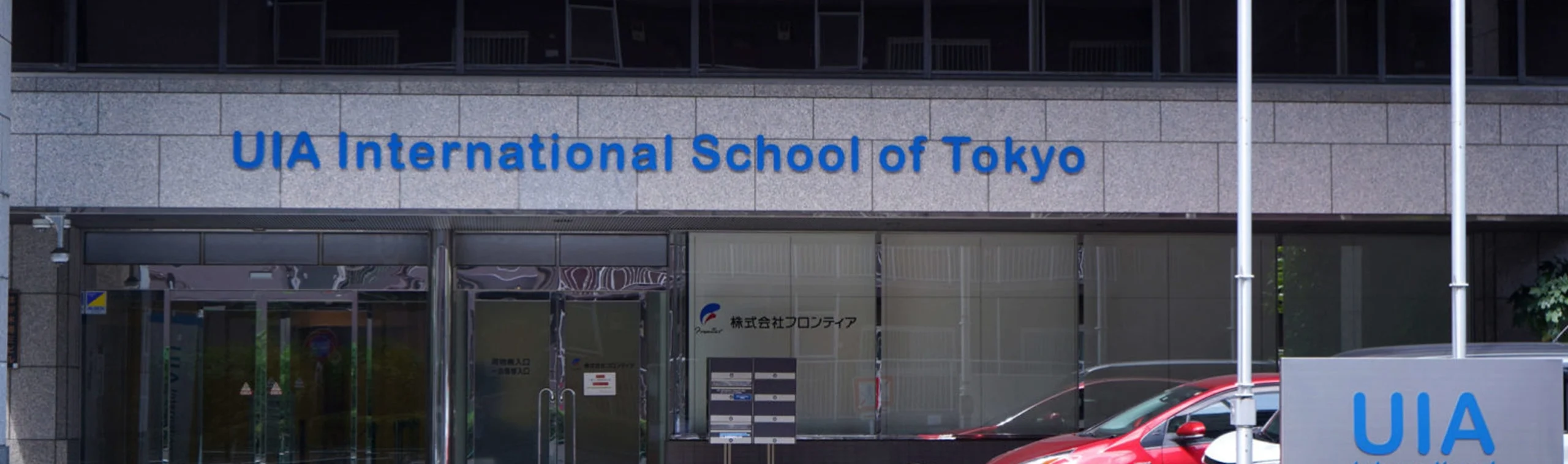 Front entrance of UIA International School of Tokyo, showcasing modern architecture and school signage.