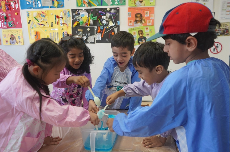 Children engaged in a fun science experiment in a classroom, mixing liquids and smiling with excitement.