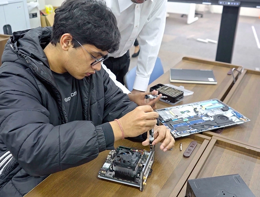 Technician assembling computer hardware components on a desk for repair or setup.